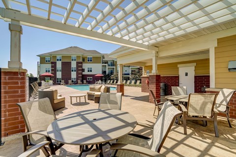 a patio with tables and chairs and a swimming pool
